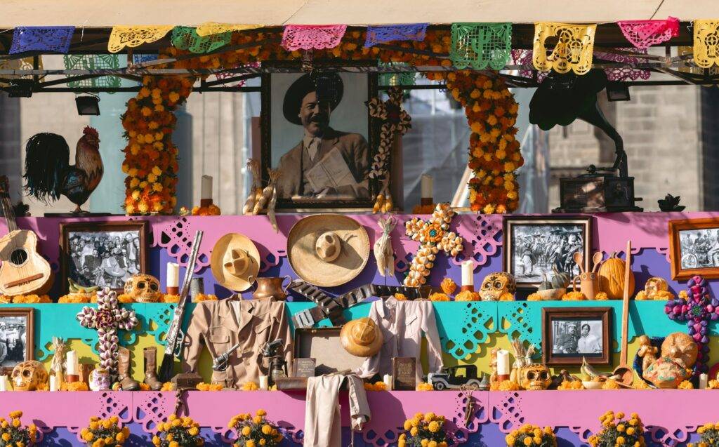 Mejor época para viajar a México 20 Altar decorado con flores, fotografías y elementos tradicionales, representando una celebración cultural en México. La escena refleja la riqueza de las tradiciones y festividades del país.
